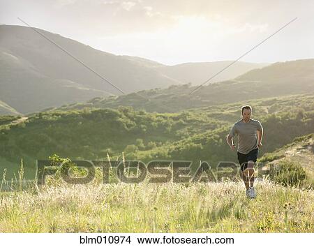 Caucasian man running on remote hill View Large Photo Image Picture - Caucasian man running on remote hill. Fotosearch