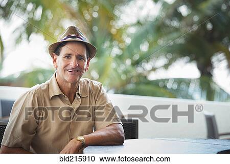 Caucasian man sitting at patio bar View Large Photo Image Stock Image - Caucasian man sitting at patio bar. Fotosearch