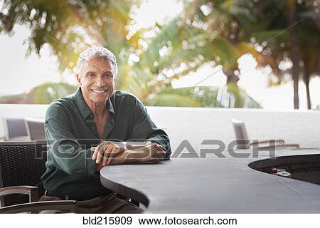 Caucasian man sitting at patio bar View Large Photo Image Stock Photo - Caucasian man sitting at patio bar. Fotosearch