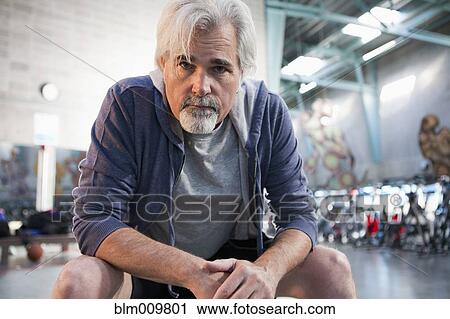 Stock Image - Caucasian man sitting in health club. Fotosearch