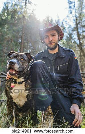 Caucasian man sitting with dog in field View Large Photo Image Stock Image - Caucasian man sitting with dog in field. Fotosearch