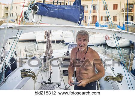 Caucasian man standing on boat docked in harbor View Large Photo Image Stock Image - Caucasian man standing on boat docked in harbor. Fotosearch
