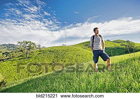 Stock Image - Caucasian man standing on rural hilltop. Fotosearch