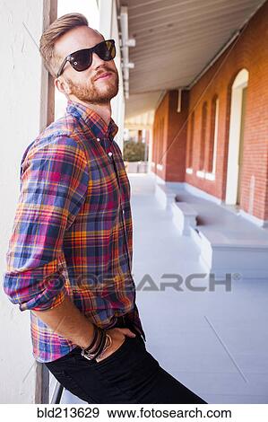 Stock Photo - Caucasian man standing under awning. Fotosearch