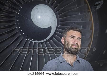 Picture - Caucasian man standing under spiral fan. Fotosearch