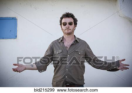 Stock Photo - Caucasian man standing with arms outstretched outdoors. Fotosearch