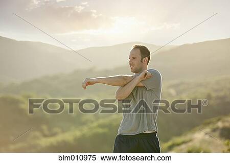 Stock Photography - Caucasian man stretching before exercise. Fotosearch