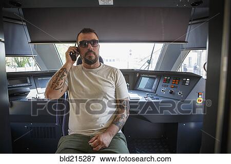 Stock Photo - Caucasian man talking on cell phone in command center. Fotosearch