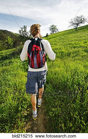 Caucasian man walking on dirt path View Large Photo Image Stock Photography - Caucasian man walking on dirt path. Fotosearch