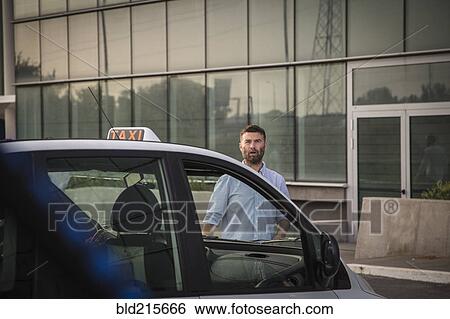 Stock Photograph - Caucasian man walking towards taxi. Fotosearch