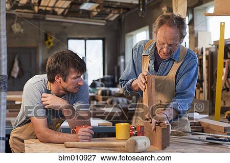 Stock Photo - Caucasian men working in carpentry workshop. Fotosearch