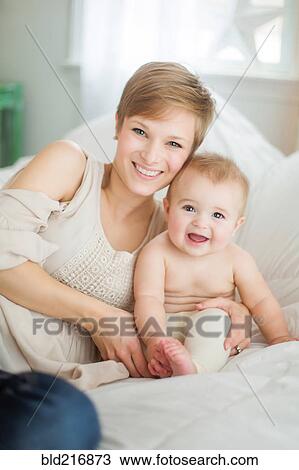 Caucasian mother and baby daughter smiling on bed View Large Photo Image Stock Image - Caucasian mother and baby daughter smiling on bed. Fotosearch