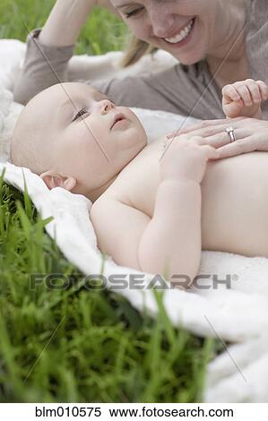 Caucasian mother and baby laying in grass View Large Photo Image Stock Photography - Caucasian mother and baby laying in grass. Fotosearch