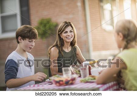Caucasian mother and children eating in backyard View Large Photo Image Stock Photography - Caucasian mother and children eating in backyard. Fotosearch