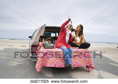 Caucasian mother and daughter eating noodles in car trunk on beach View Large Photo Image Stock Photography - Caucasian mother and daughter eating noodles in car trunk on beach. Fotosearch