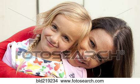 Picture - Caucasian mother and daughter smiling outdoors. Fotosearch