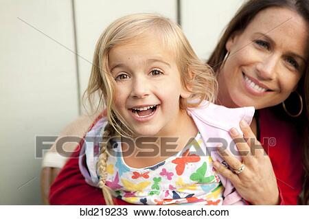Stock Image - Caucasian mother and daughter smiling outdoors. Fotosearch