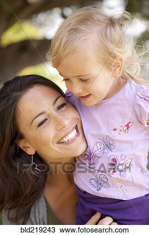 Stock Image - Caucasian mother and daughter smiling outdoors. Fotosearch