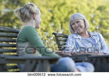 Stock Image - Caucasian mother and daughter talking outdoors. Fotosearch