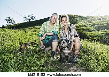 Caucasian mother and daughter walking dogs on grassy hillside View Large Photo Image Stock Image - Caucasian mother and daughter walking dogs on grassy hillside. Fotosearch
