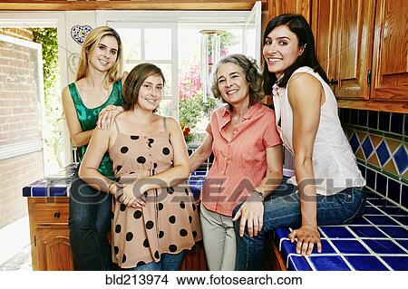 Caucasian mother and daughters smiling in kitchen View Large Photo Image Picture - Caucasian mother and daughters smiling in kitchen. Fotosearch