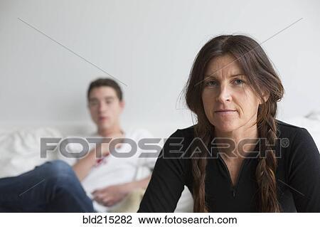 Stock Image - Caucasian mother and son sitting in living room. Fotosearch