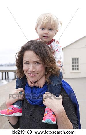 Caucasian mother carrying daughter on shoulders View Large Photo Image Stock Photo - Caucasian mother carrying daughter on shoulders. Fotosearch