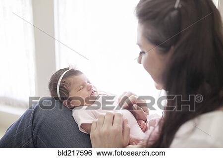 Stock Photograph - Caucasian mother cradling baby girl. Fotosearch