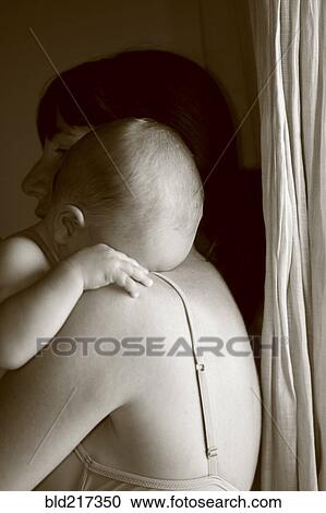 Stock Image - Caucasian mother holding crying baby. Fotosearch