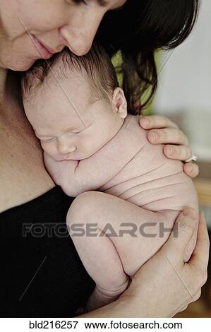 Stock Photo - Caucasian mother holding newborn baby. Fotosearch