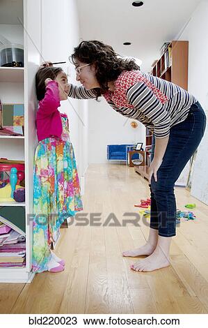 Caucasian mother measuring height of daughter on wall View Large Photo Image Stock Image - Caucasian mother measuring height of daughter on wall. Fotosearch