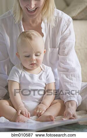 Caucasian mother reading book to baby View Large Photo Image Stock Photo - Caucasian mother reading book to baby. Fotosearch