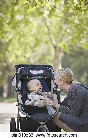 Stock Image - Caucasian mother with baby in stroller. Fotosearch