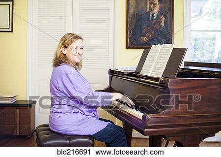 Stock Image - Caucasian musician playing piano. Fotosearch