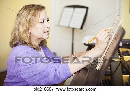 Caucasian musician writing sheet music at piano View Large Photo Image Stock Photo - Caucasian musician writing sheet music at piano. Fotosearch