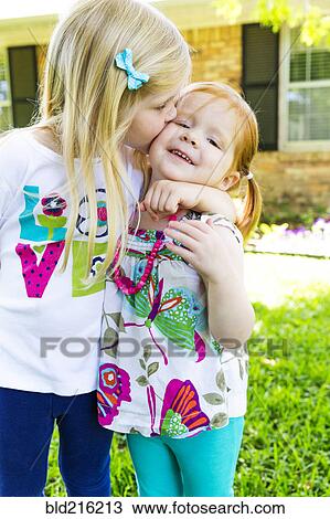 Caucasian sisters kissing in backyard View Large Photo Image Stock Image - Caucasian sisters kissing in backyard. Fotosearch