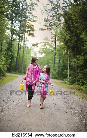 Picture - Caucasian sisters walking on dirt road. Fotosearch