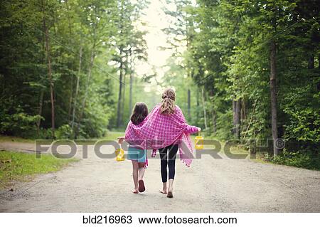 Caucasian sisters walking on dirt road View Large Photo Image Stock Image - Caucasian sisters walking on dirt road. Fotosearch