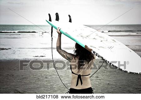 Caucasian surfer carrying surfboard on beach View Large Photo Image Stock Photo - Caucasian surfer carrying surfboard on beach. Fotosearch