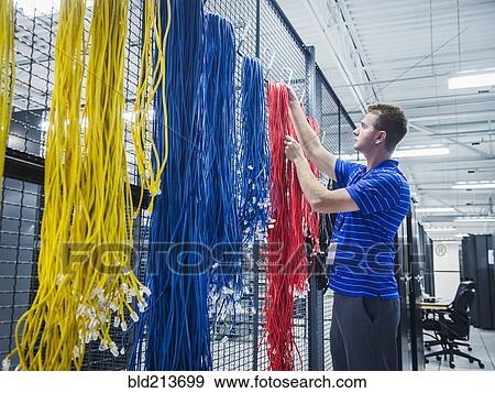 Caucasian technician hanging cables in server room View Large Photo Image Stock Photo - Caucasian technician hanging cables in server room. Fotosearch