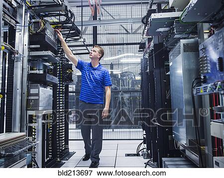 Stock Photo - Caucasian technician working in server room. Fotosearch