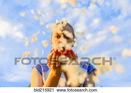 Caucasian teenage girl blowing flower petals under blue sky View Large Photo Image Stock Image - Caucasian teenage girl blowing flower petals under blue sky. Fotosearch