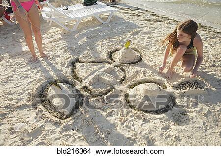 Caucasian teenage girl building sandcastle on beach View Large Photo Image Picture - Caucasian teenage girl building sandcastle on beach. Fotosearch