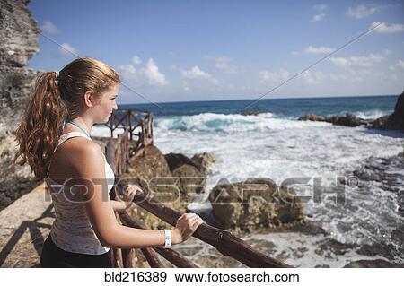 Stock Photo - Caucasian teenage girl enjoying ocean view. Fotosearch