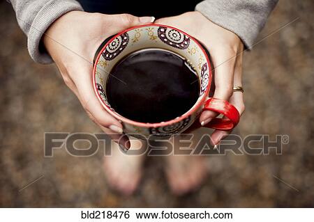 Stock Photograph - Caucasian teenage girl holding cup of coffee. Fotosearch