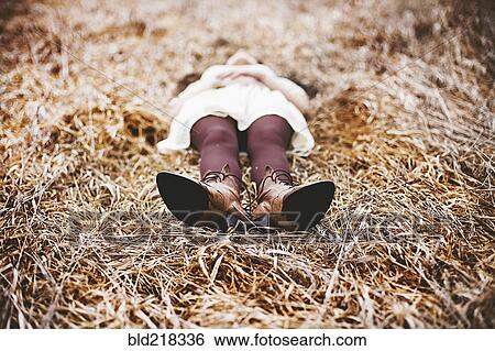 Stock Photograph - Caucasian teenage girl laying in tall grass. Fotosearch