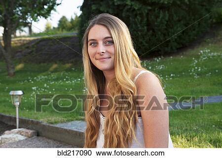 Stock Image - Caucasian teenage girl smiling in park. Fotosearch