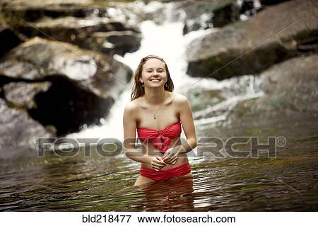 Caucasian teenage girl standing in river near waterfall View Large Photo Image Stock Photo - Caucasian teenage girl standing in river near waterfall. Fotosearch