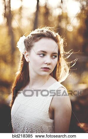 Stock Photography - Caucasian teenage girl standing in forest. Fotosearch