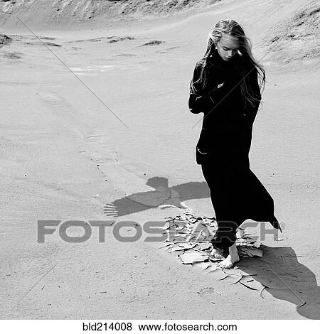 Stock Photo - Caucasian teenage girl standing on beach near shadow of eagle. Fotosearch